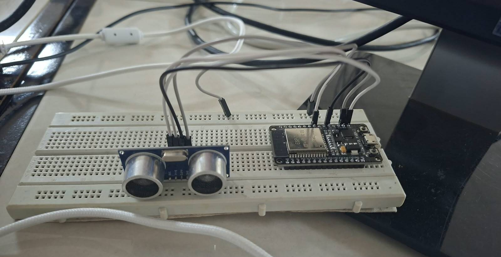 Breadboard prototype of the ESP32 edge node with the HC-SR04 ultrasonic sensor wired for development and bench testing.